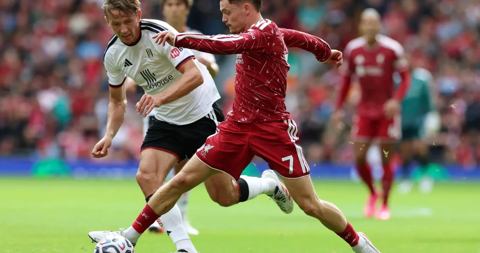 Jugador de Liverpool compitiendo por el balón Jugador de Liverpool compitiendo por el balón
