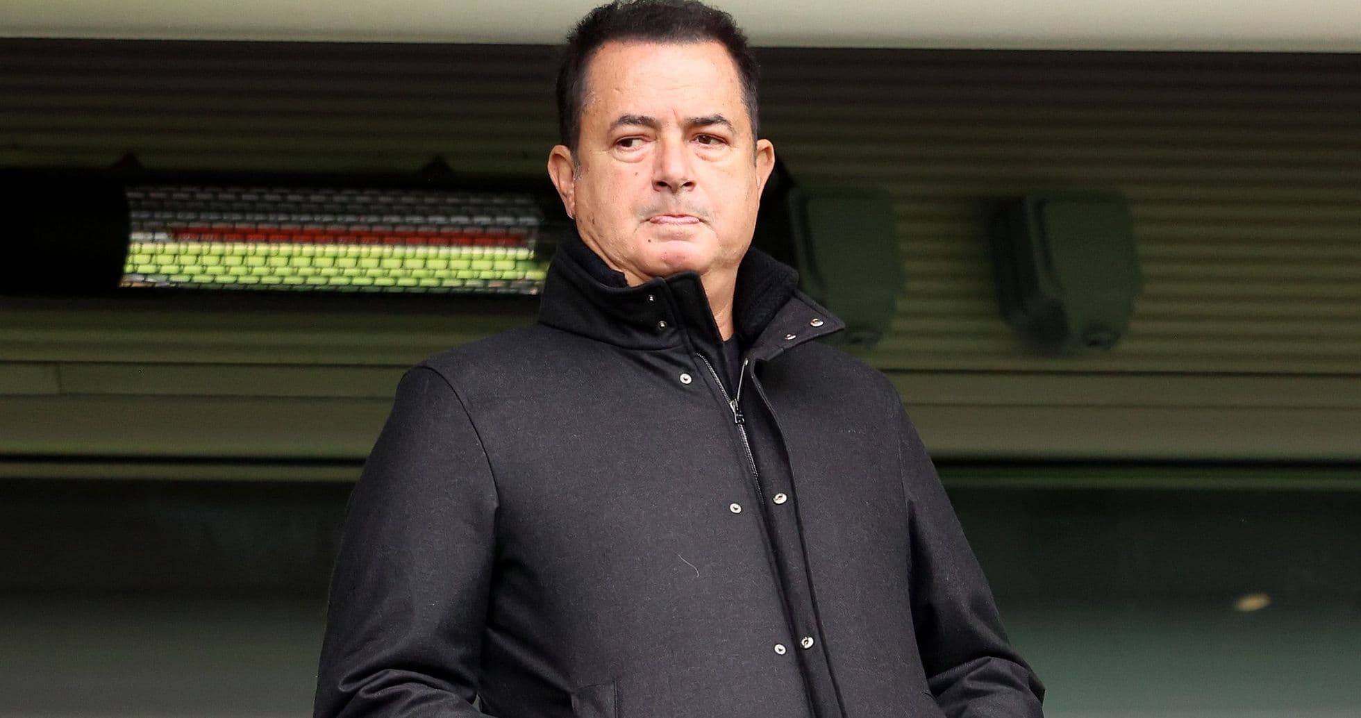 Hombre con abrigo negro en un estadio Hombre con abrigo negro en un estadio