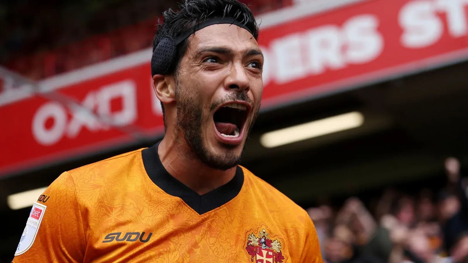 Jugador celebrando con camiseta naranja en estadio Jugador celebrando con camiseta naranja en estadio