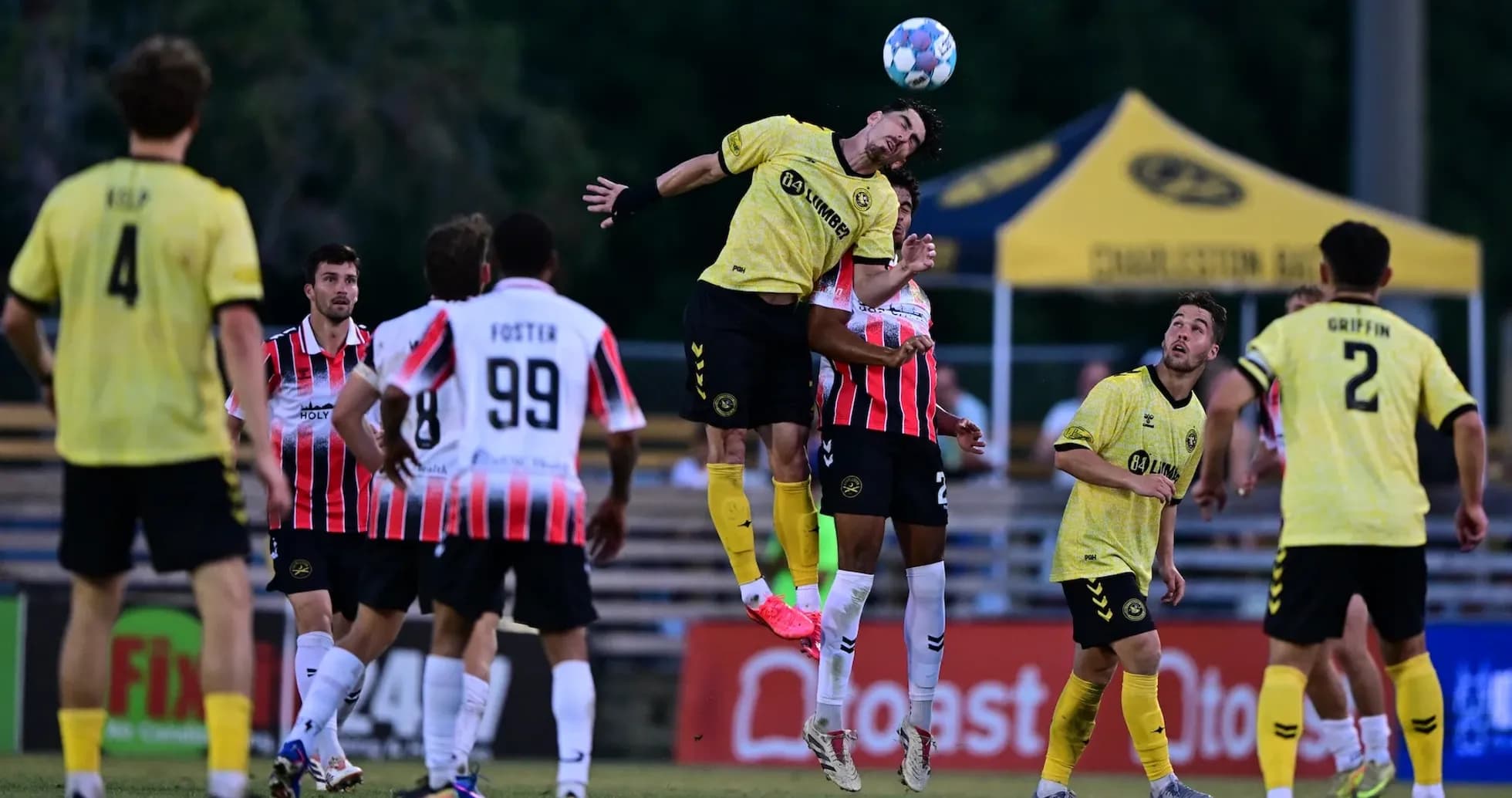 Jugador salta para cabecear el balón en el partido Jugador salta para cabecear el balón en el partido