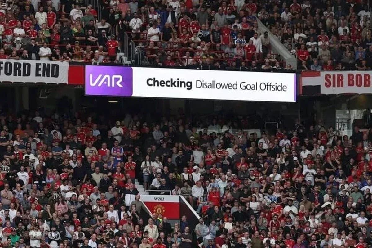 A crowd watching VAR review disallowed goal sign A crowd watching VAR review disallowed goal sign