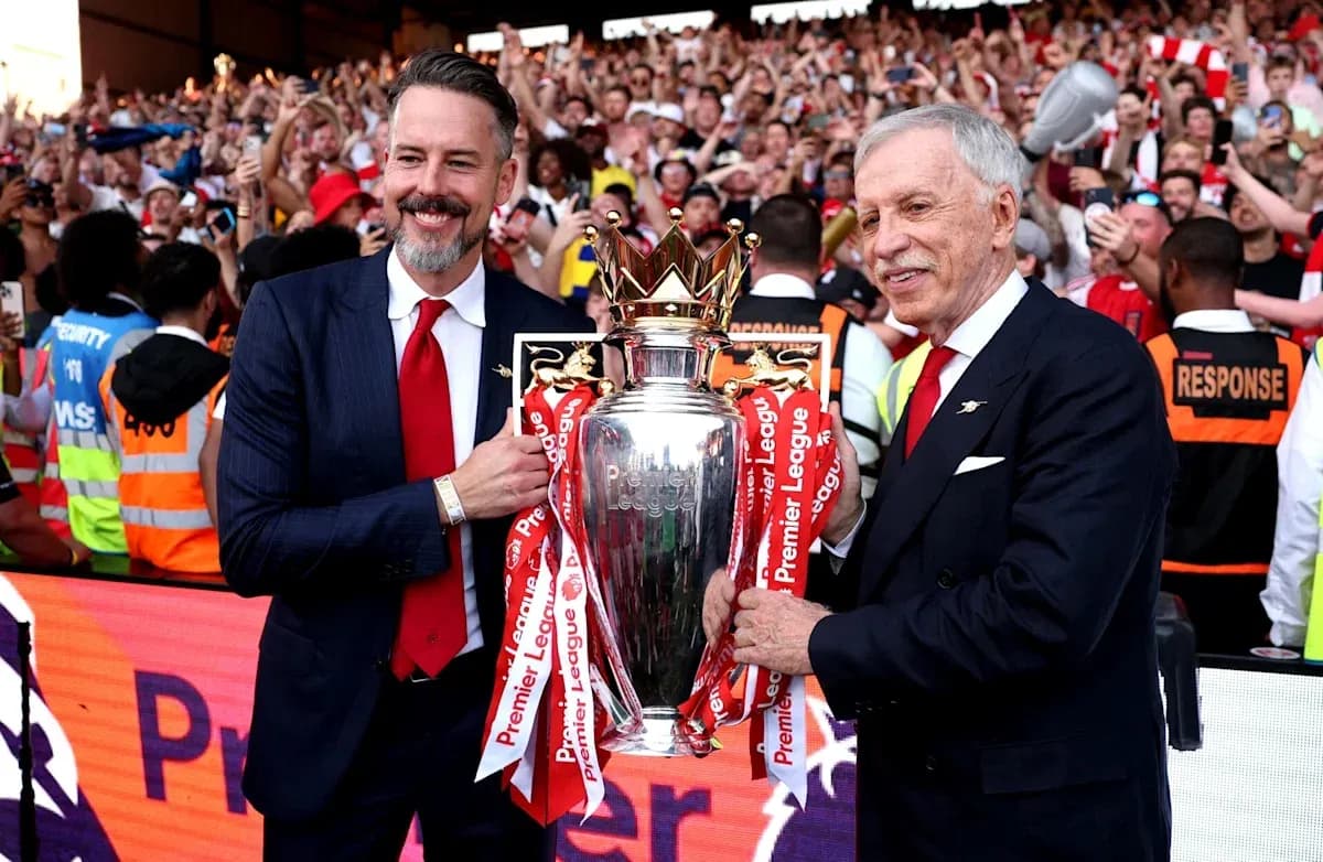 Dos personas sosteniendo el trofeo de la Premier League Dos personas sosteniendo el trofeo de la Premier League