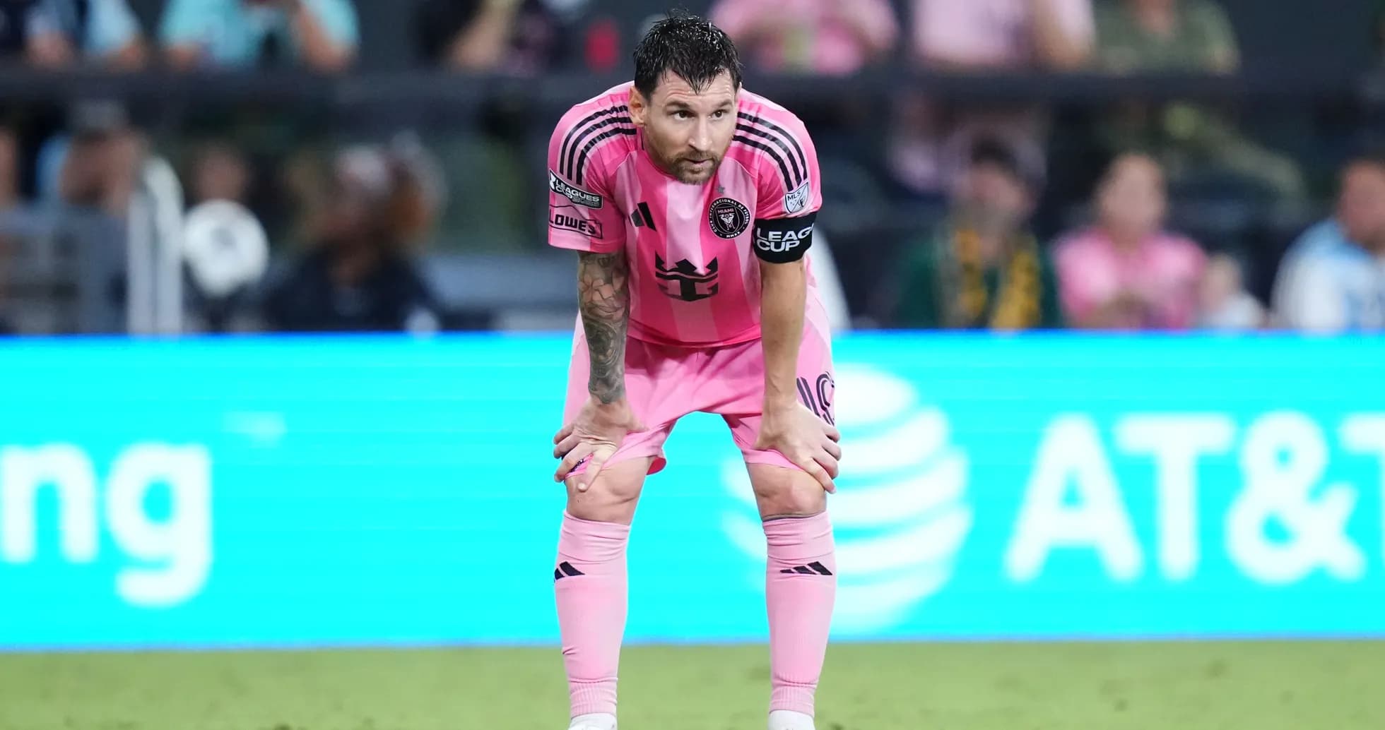 Jugador con camiseta rosa descansando en el campo Jugador con camiseta rosa descansando en el campo