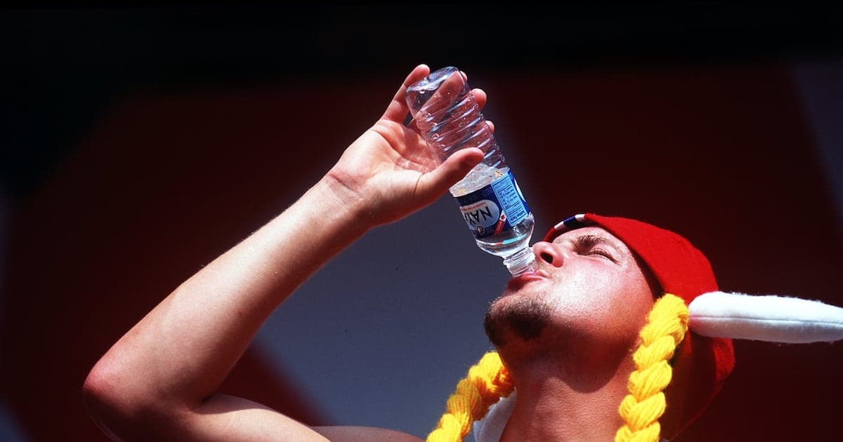 Hombre bebiendo agua de botella con gorro rojo Hombre bebiendo agua de botella con gorro rojo