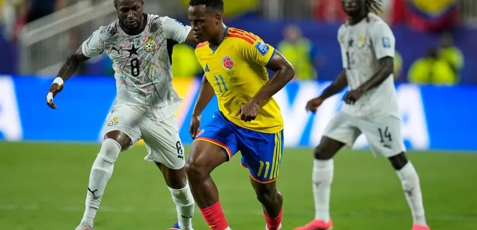 Jugador colombiano driblando a oponente ghanés en partido Jugador colombiano driblando a oponente ghanés en partido