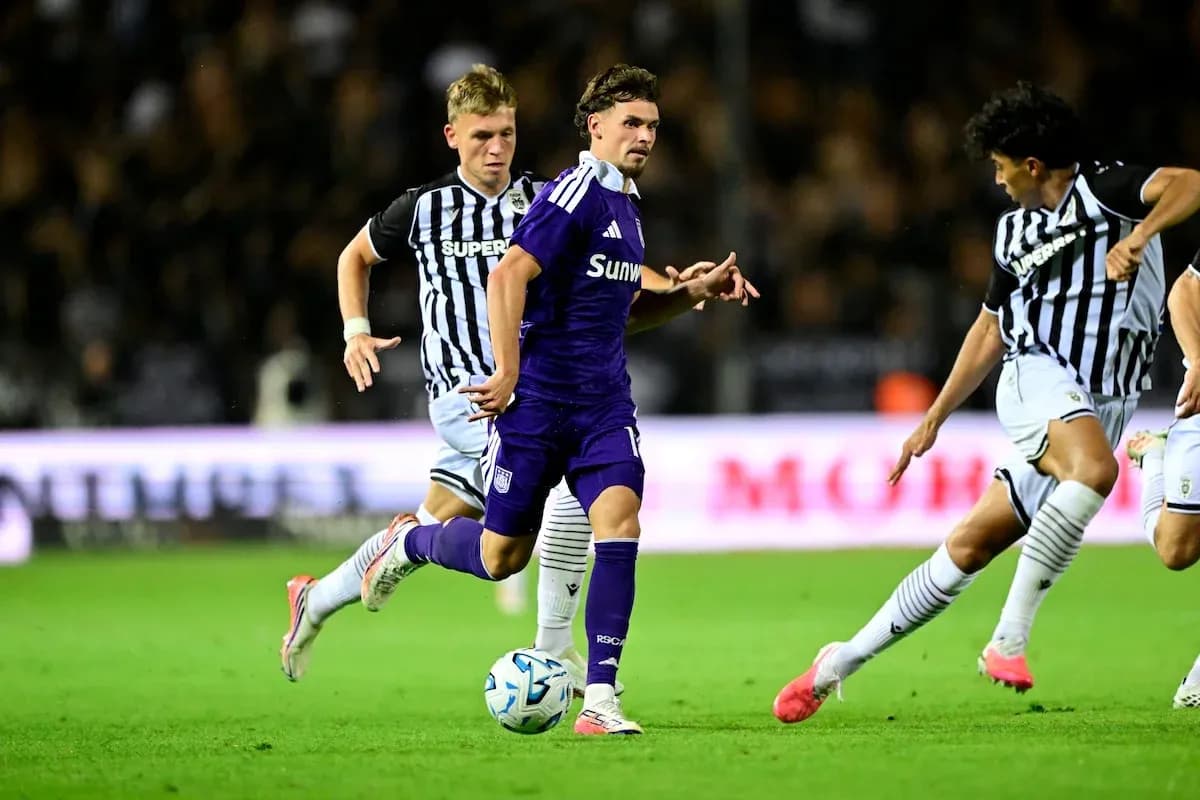 Jugador de Anderlecht esquivando a defensores de PAOK Jugador de Anderlecht esquivando a defensores de PAOK