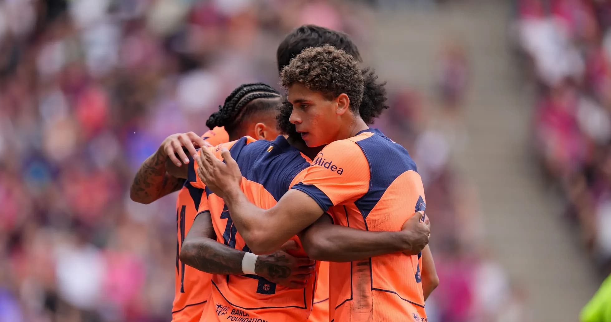 Jugadores abrazándose tras un gol en partido Jugadores abrazándose tras un gol en partido