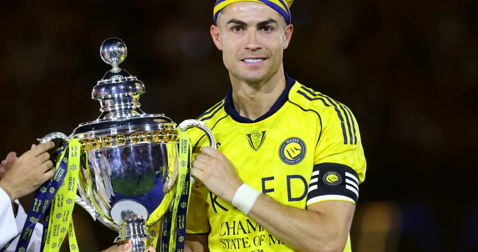 Jugador sosteniendo trofeo en celebración de campeonato Jugador sosteniendo trofeo en celebración de campeonato