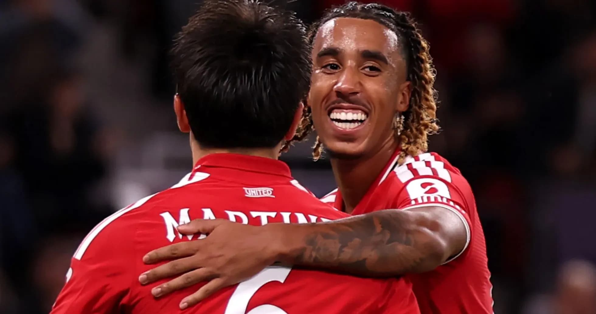 Jugadores abrazándose tras un gol en partido Jugadores abrazándose tras un gol en partido