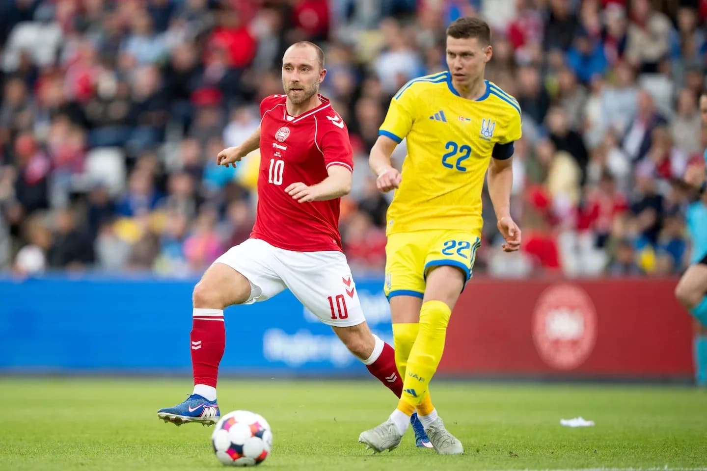 Jugador danés y ucraniano compitiendo por el balón Jugador danés y ucraniano compitiendo por el balón