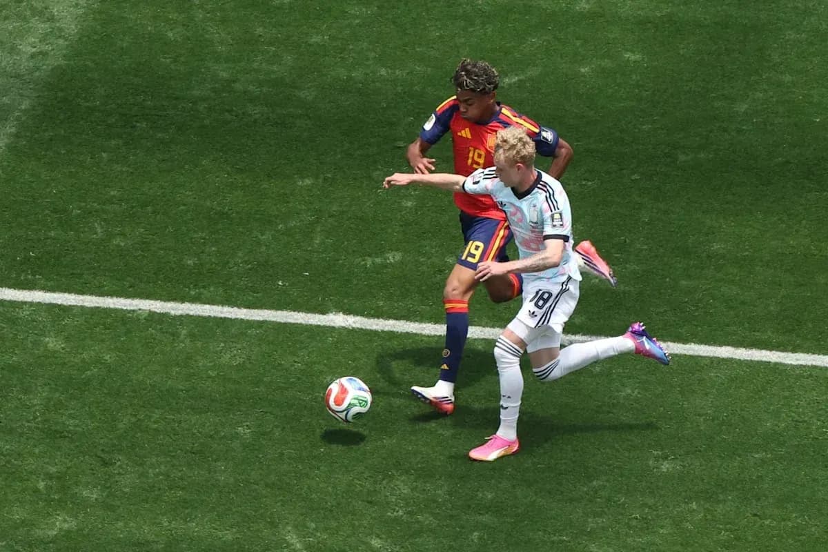Jugador de Alemania desafiando a rival español en campo Jugador de Alemania desafiando a rival español en campo