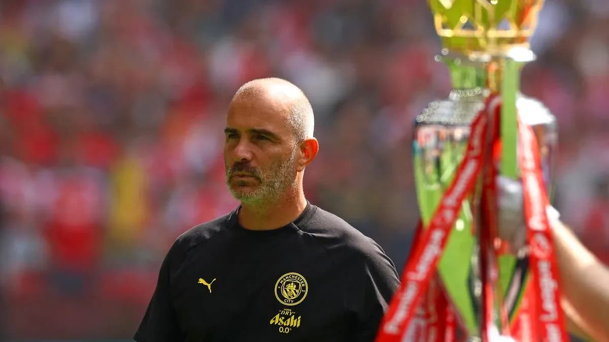 Entrenador de Manchester City observando trofeo en campo Entrenador de Manchester City observando trofeo en campo