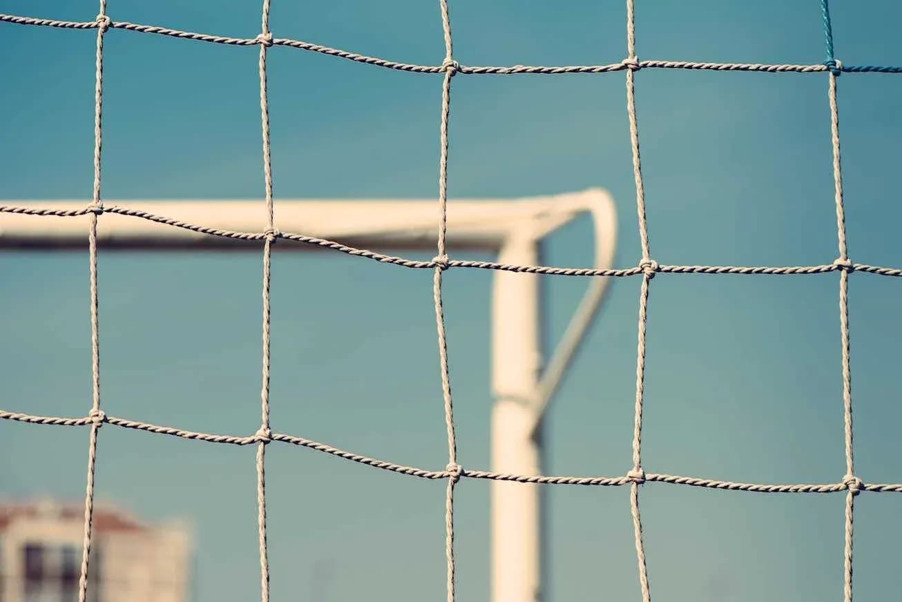 Red de un arco de fútbol con fondo azul Red de un arco de fútbol con fondo azul