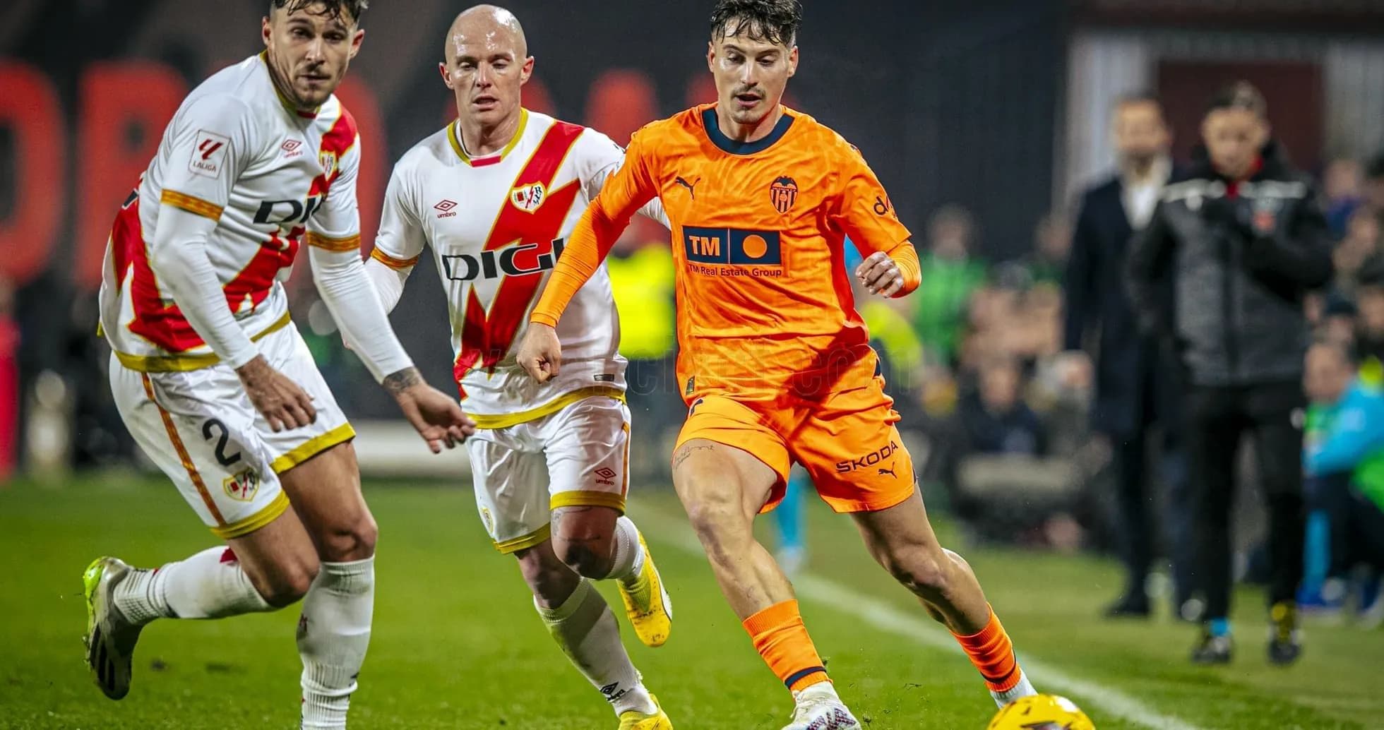 Jugador de Valencia esquivando a defensores de Rayo Vallecano Jugador de Valencia esquivando a defensores de Rayo Vallecano