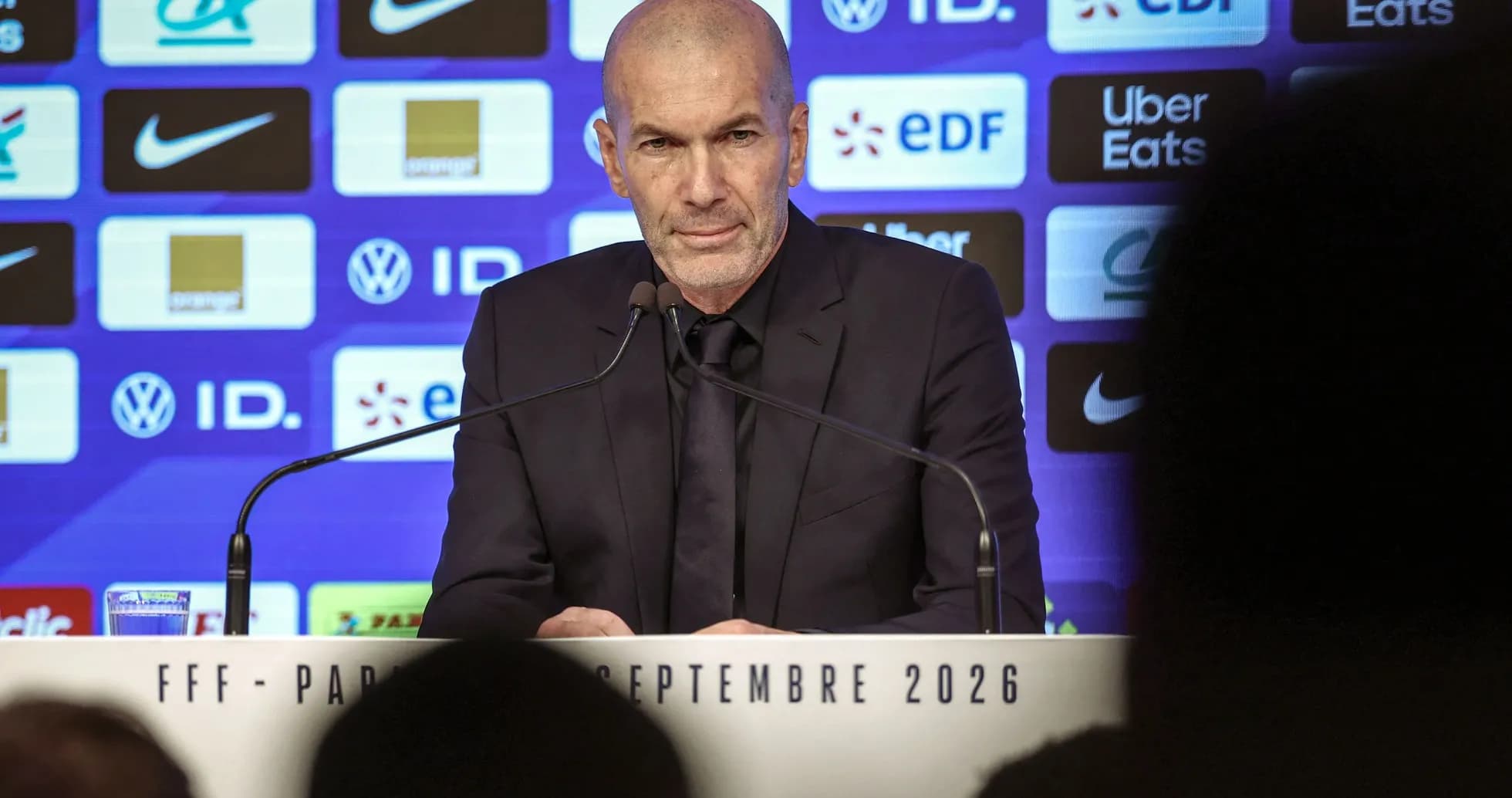 Entrenador en conferencia de prensa con fondo de logos Entrenador en conferencia de prensa con fondo de logos