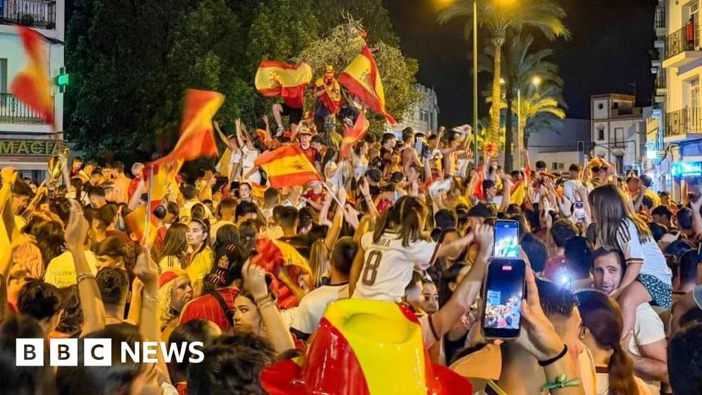 Multitud celebrando con banderas en la calle Multitud celebrando con banderas en la calle