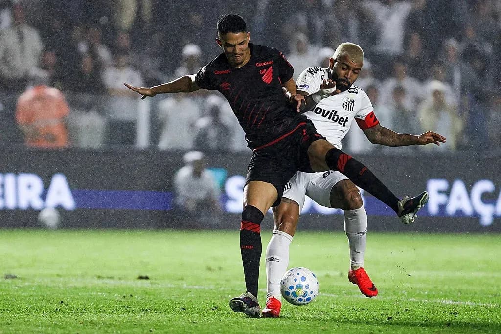 Jugadores compitiendo por el balón en la lluvia Jugadores compitiendo por el balón en la lluvia