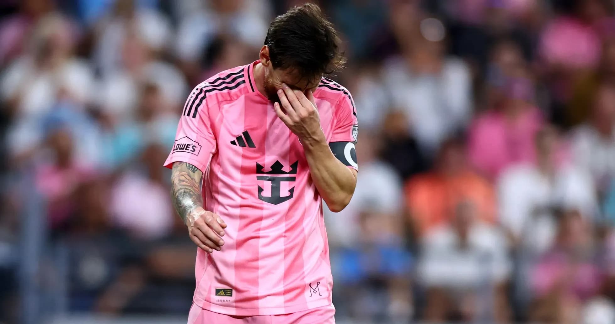 Jugador con camiseta rosa caminando por el campo Jugador con camiseta rosa caminando por el campo