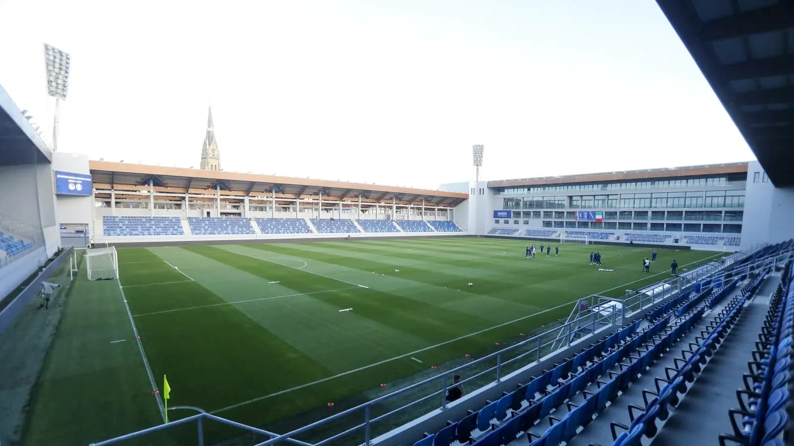 Vista del estadio con jugadores en el campo de entrenamiento Vista del estadio con jugadores en el campo de entrenamiento