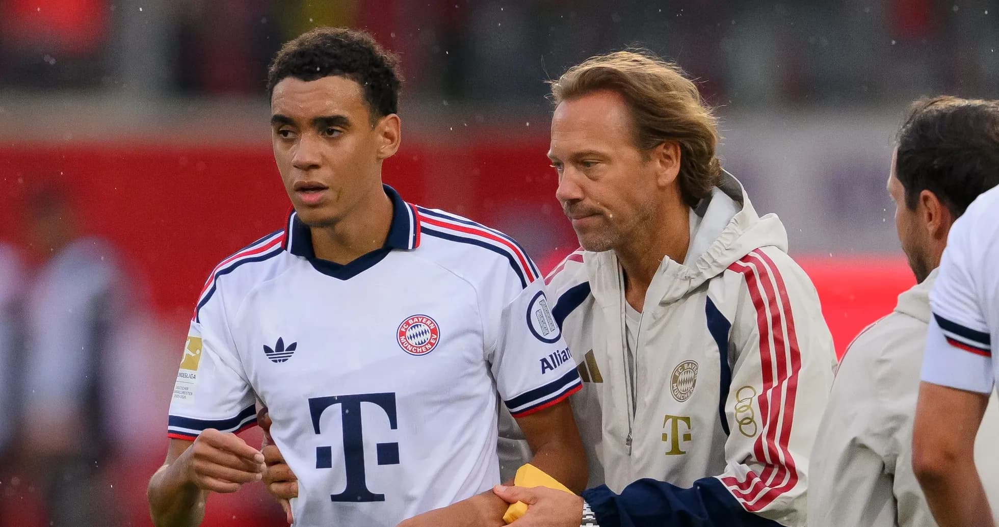 Jugador de Bayern Múnich siendo atendido por el entrenador Jugador de Bayern Múnich siendo atendido por el entrenador