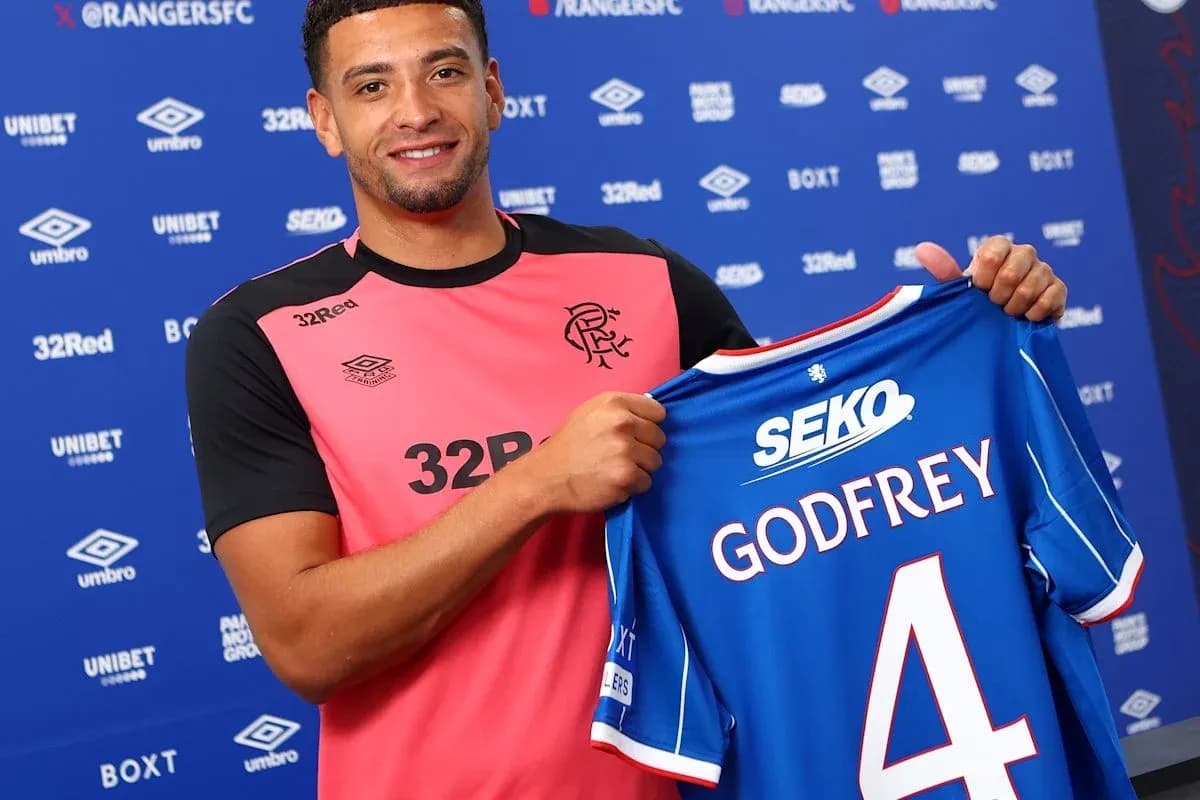 Jugador sosteniendo camiseta de Rangers con nombre Godfrey Jugador sosteniendo camiseta de Rangers con nombre Godfrey