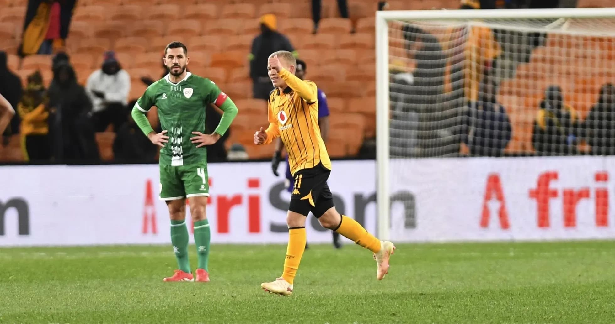 Jugador de Kaizer Chiefs celebrando con rival en el fondo Jugador de Kaizer Chiefs celebrando con rival en el fondo