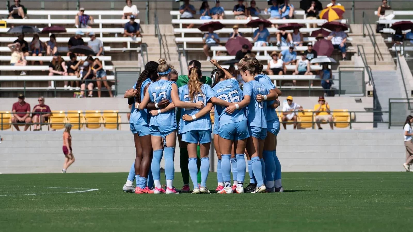 Equipo femenino de fútbol en círculo antes del partido Equipo femenino de fútbol en círculo antes del partido