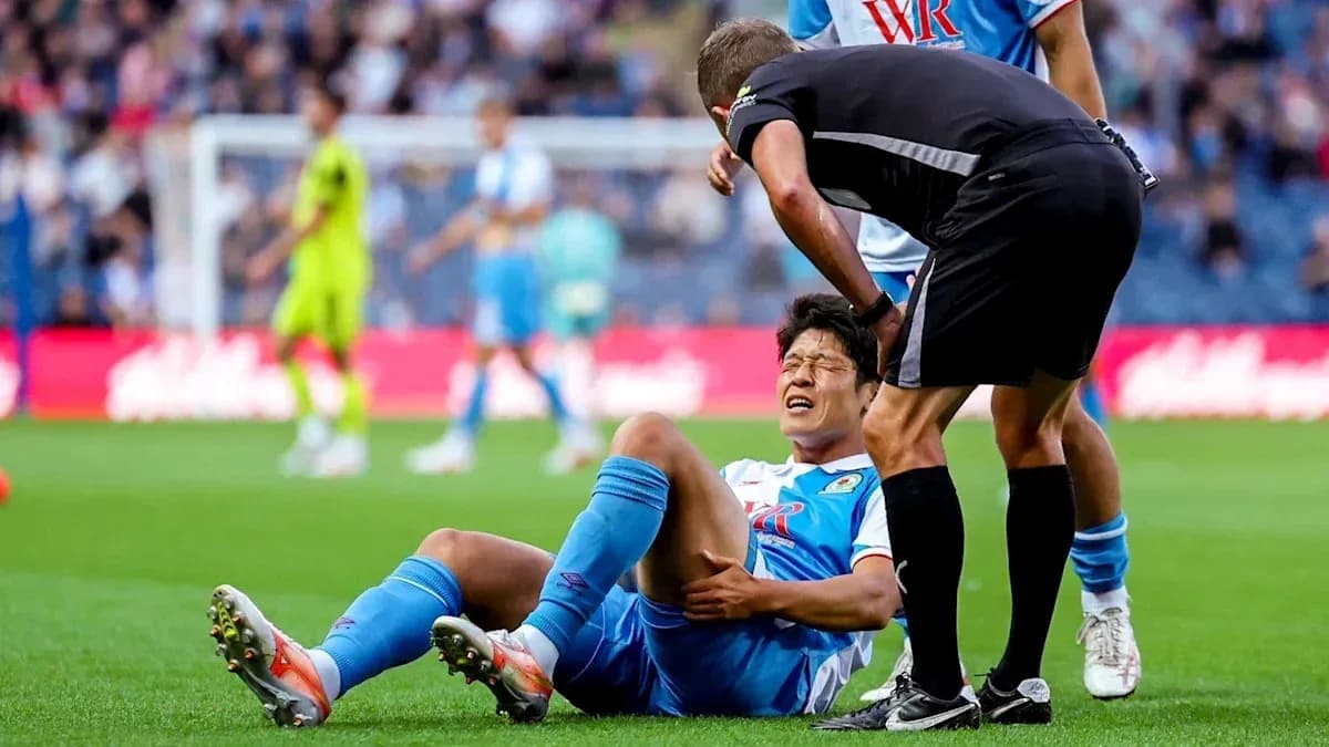 Jugador caído con dolor siendo atendido por el árbitro Jugador caído con dolor siendo atendido por el árbitro