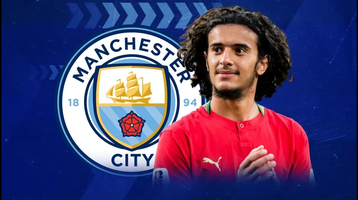 Jugador de Manchester City frente al logo del equipo Jugador de Manchester City frente al logo del equipo
