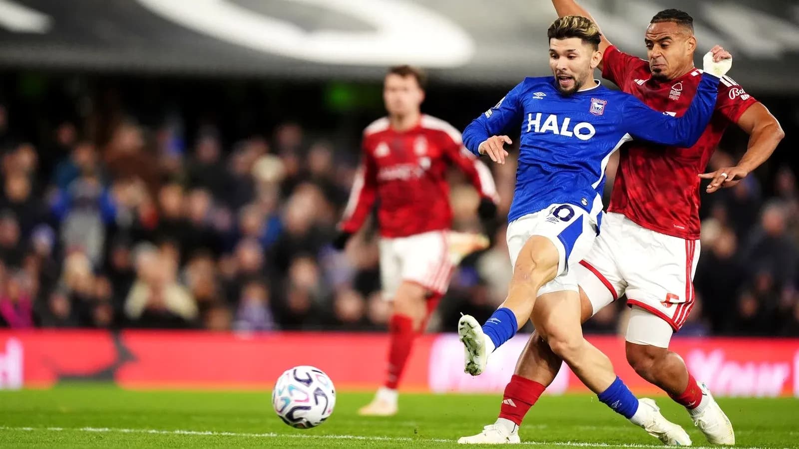 Jugador de Ipswich siendo desafiado por oponente Jugador de Ipswich siendo desafiado por oponente