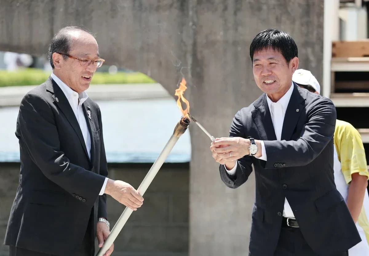 Dos personas encendiendo una antorcha en ceremonia Dos personas encendiendo una antorcha en ceremonia
