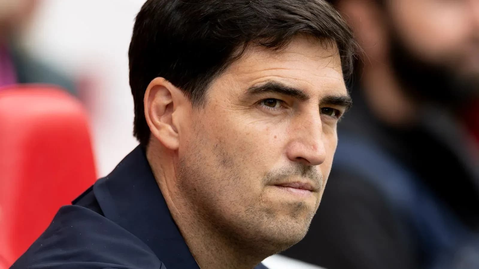 Entrenador observando desde el banquillo durante el partido Entrenador observando desde el banquillo durante el partido