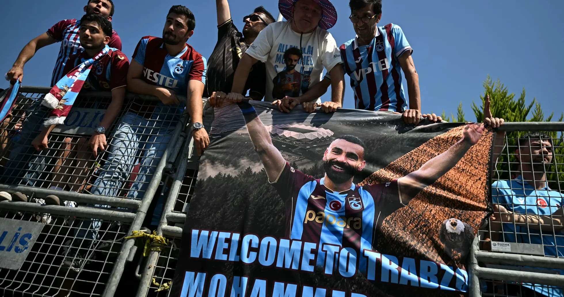 Aficionados con pancarta de bienvenida a jugador Aficionados con pancarta de bienvenida a jugador