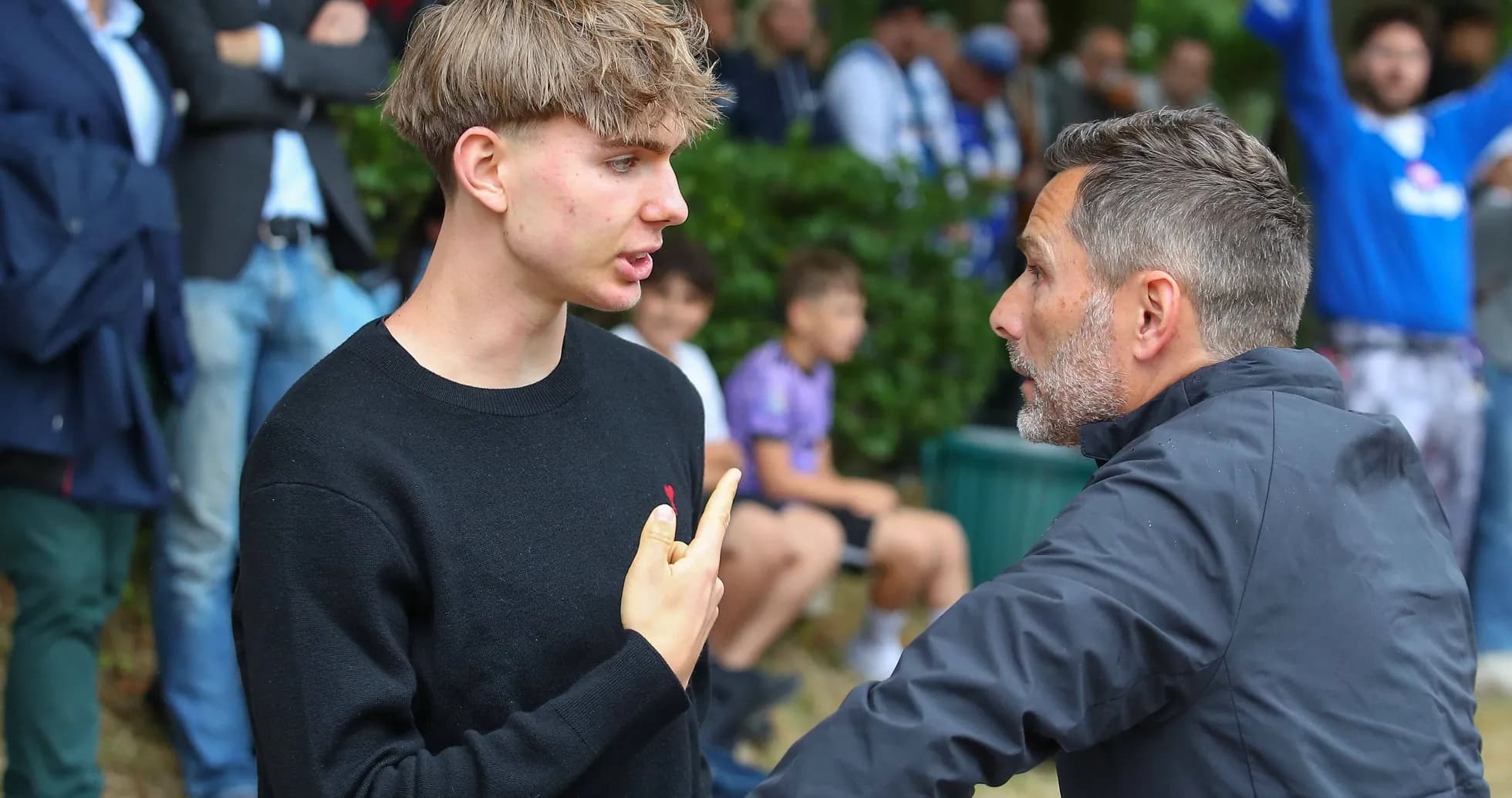 Joven discutiendo con un hombre en un evento deportivo Joven discutiendo con un hombre en un evento deportivo