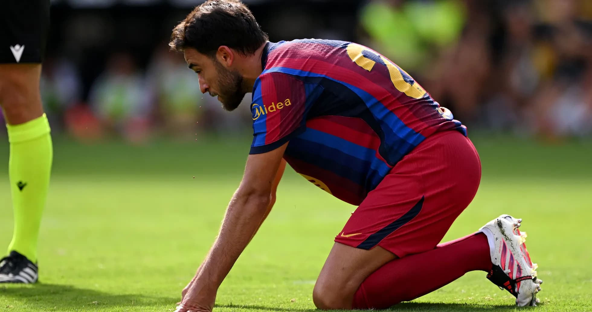 Jugador de Barcelona arrodillado en el campo de juego Jugador de Barcelona arrodillado en el campo de juego