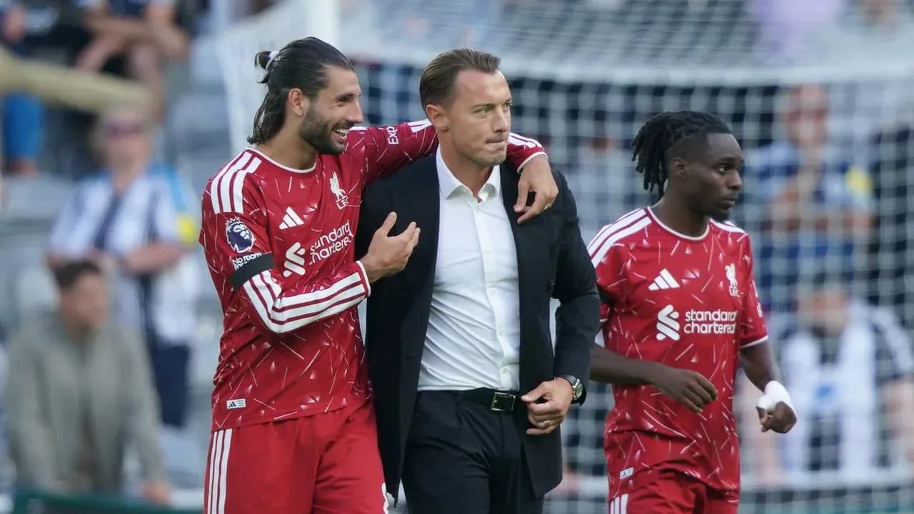 Jugadores de Liverpool celebrando con entrenador en el campo Jugadores de Liverpool celebrando con entrenador en el campo
