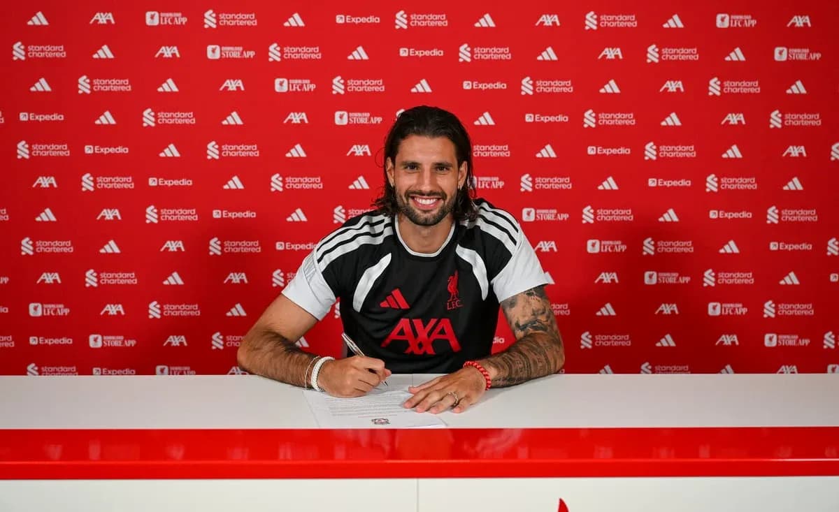 Jugador firmando contrato en mesa de prensa Jugador firmando contrato en mesa de prensa