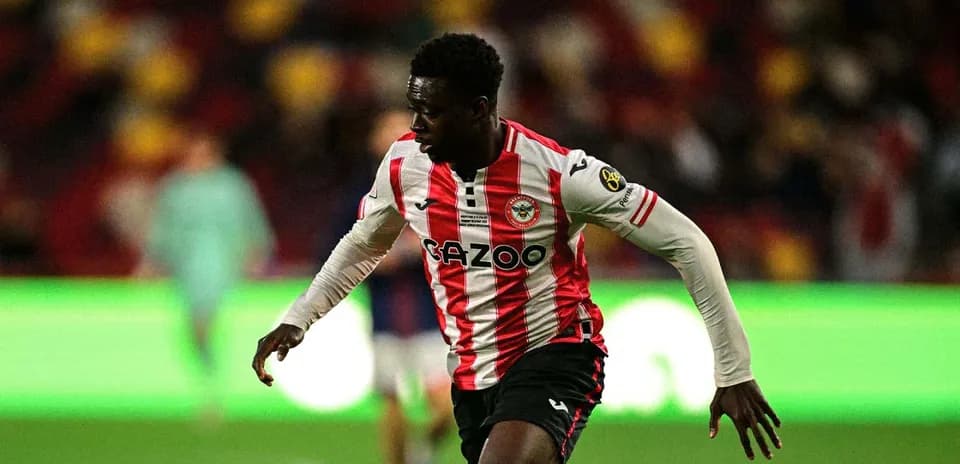 Jugador de Brentford corriendo con balón en el campo Jugador de Brentford corriendo con balón en el campo