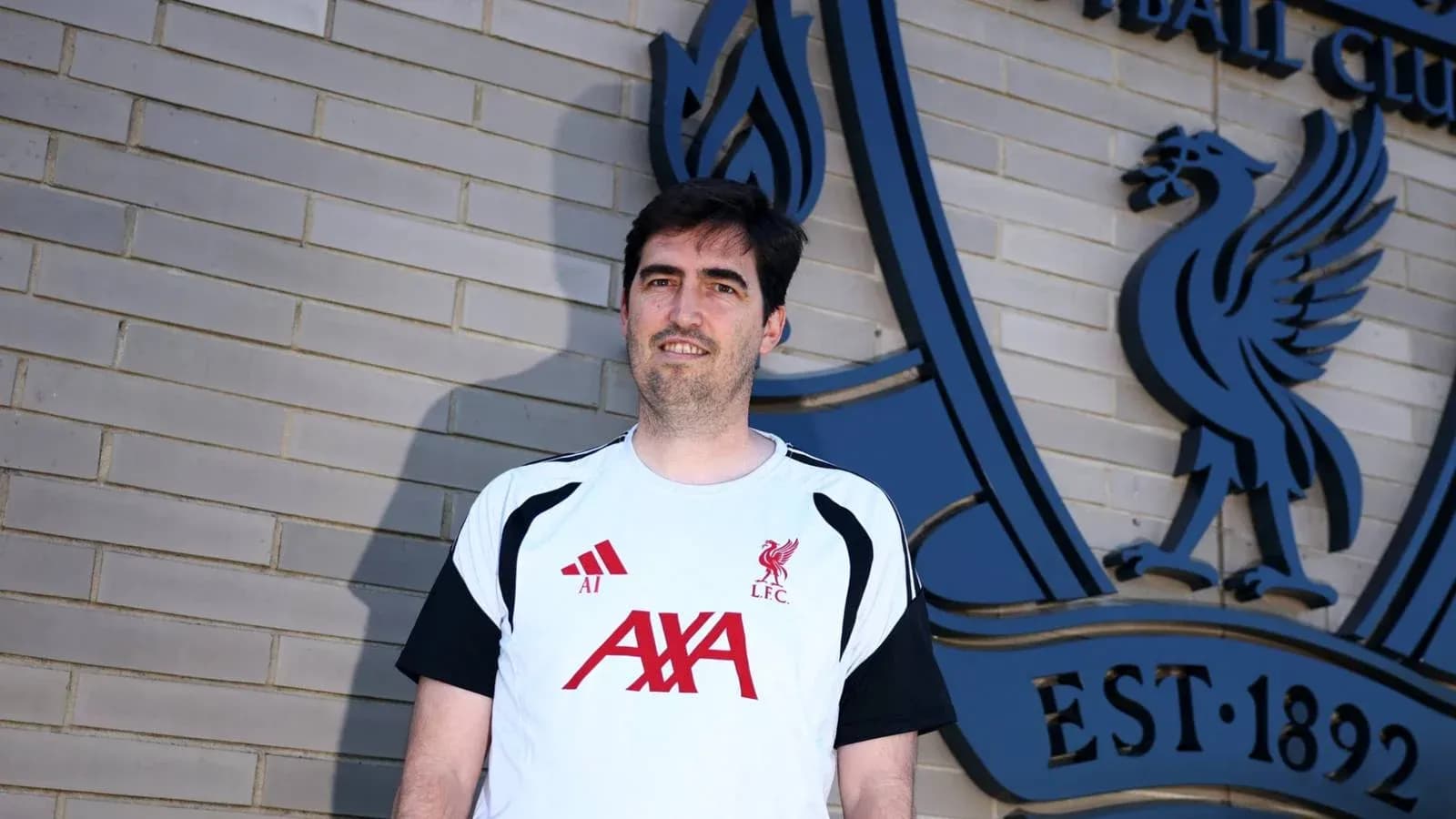 Persona posando frente al logo del Liverpool FC Persona posando frente al logo del Liverpool FC
