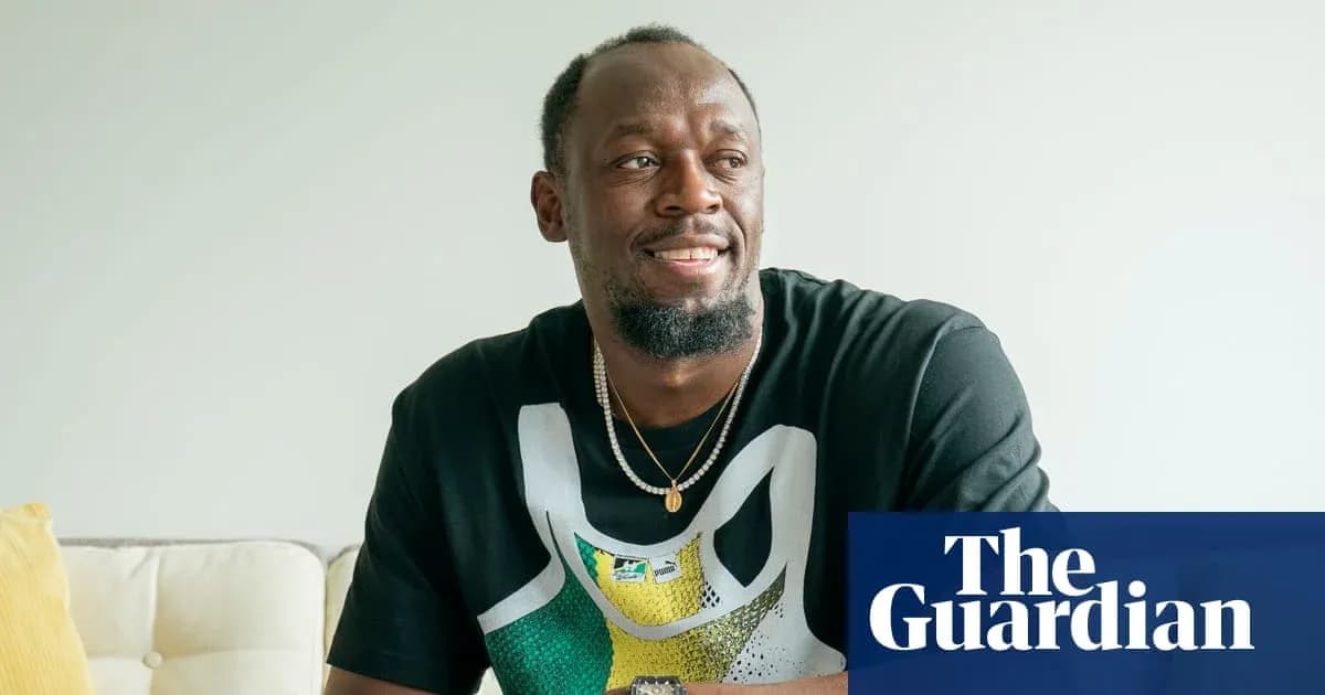 Atleta sonriendo sentado en sofá con camiseta Atleta sonriendo sentado en sofá con camiseta